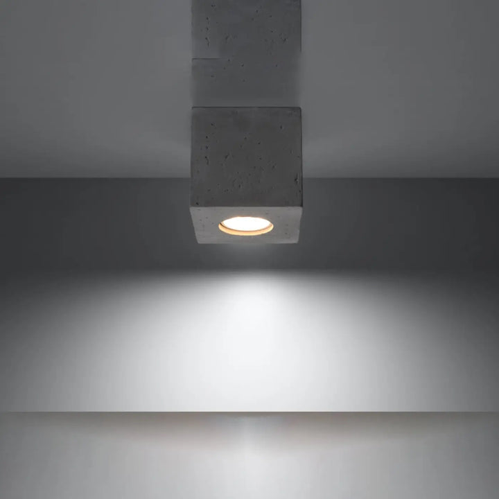 Luminaire plafonnier quad beton gris beton en cube concret avec une lueur circulaire chaude