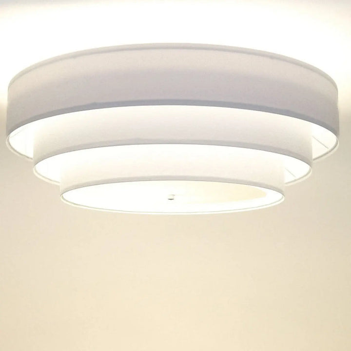Luminaire plafonnier blanc moderne avec diffuseur rond à trois anneaux concentriques pour une lumière douce et uniforme