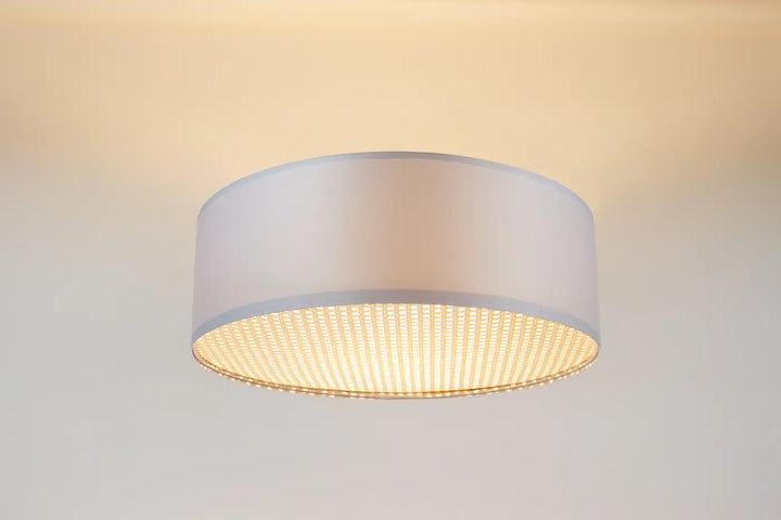 Luminaire plafonnier blanc cylindrique avec abat-jour en tissu blanc perle et base perforée dorée éclaireuse