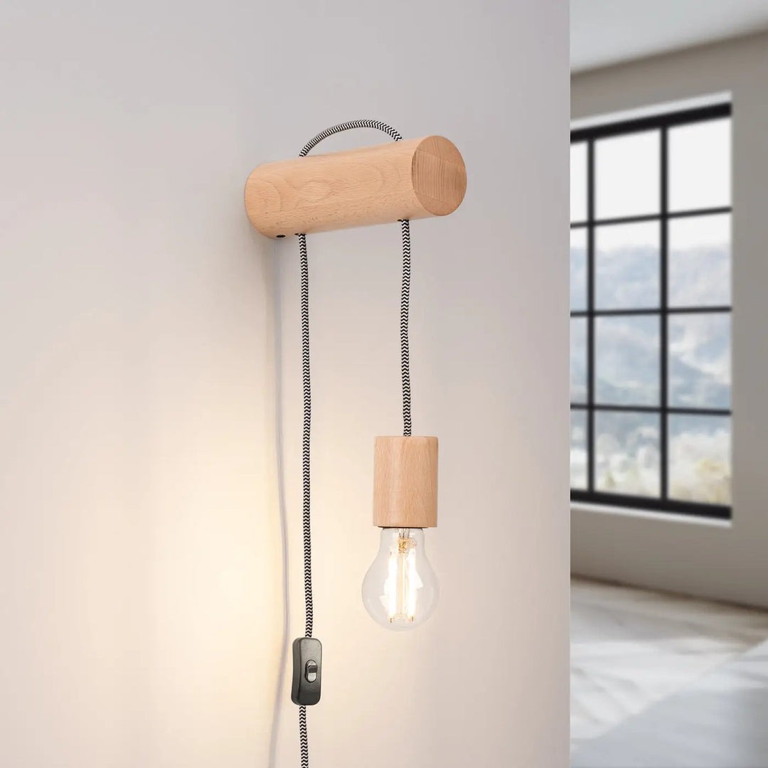 L’applique murale nimbi en bois léger naturel avec cordon tressé noir et ampoule edison visible pour cheminée nimbi