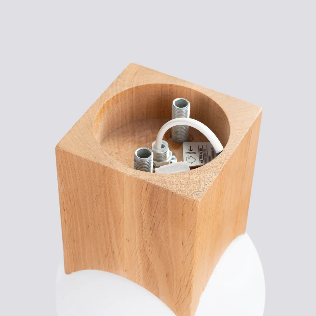 Base de lampe solis en bois naturel léger avec câblage interne visible et connecteurs métalliques pour abat-jour sphérique design minimaliste