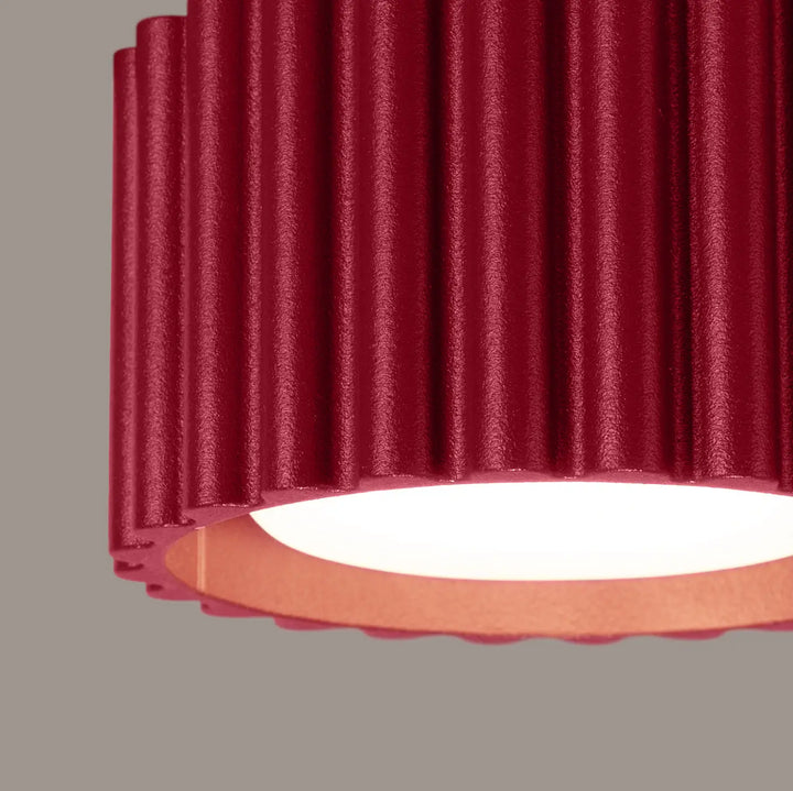 Plafonnier aura 1 bordeaux avec forme unique inspirée en métal rouge nervuré et base circulaire cuivrée