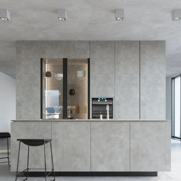 Cuisine moderne avec îlot en béton durable et cabinet vitré noir intégré sous plafonnier valde facile à nettoyer