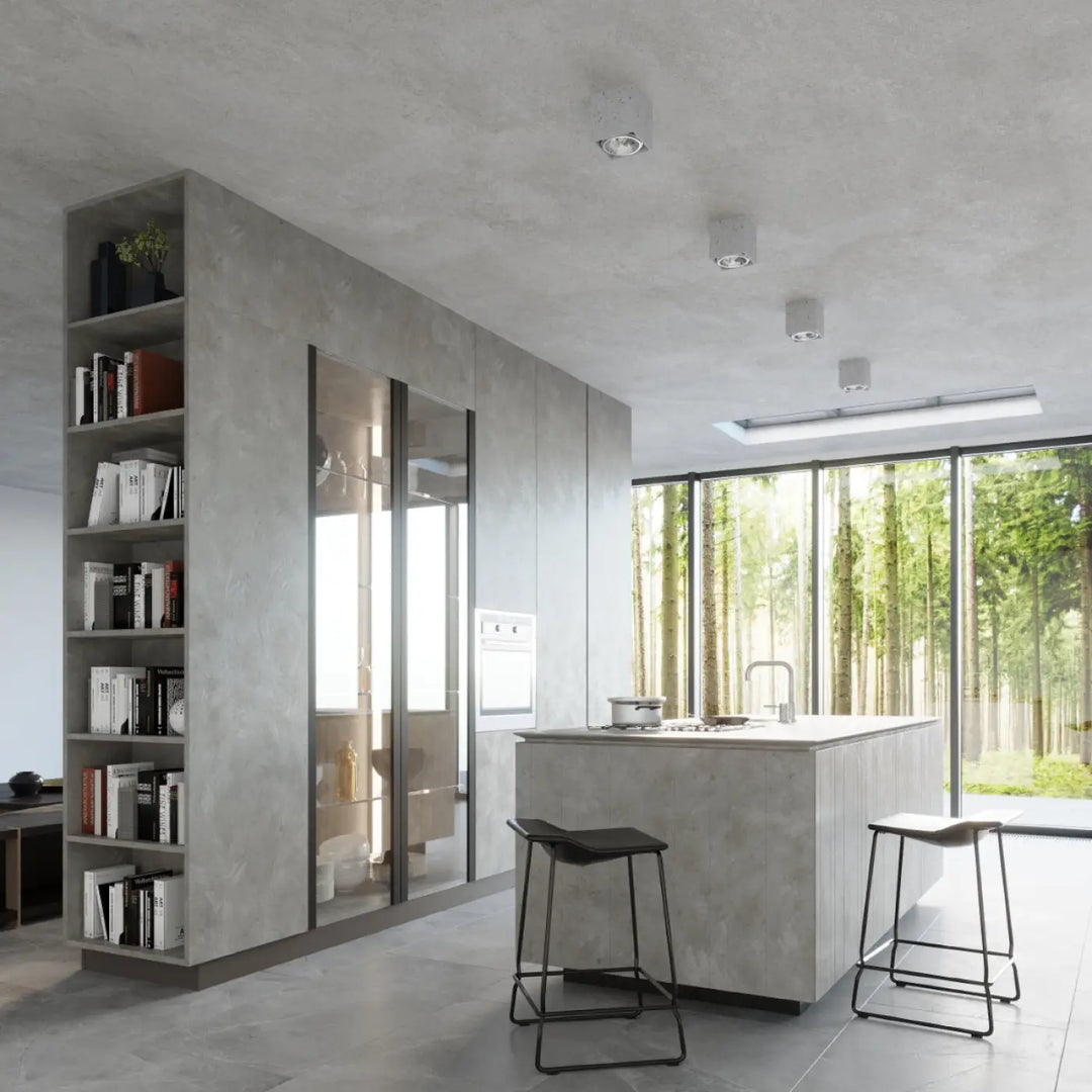 Plafonnier valde en béton durable avec îlot de cuisine texturé facile à nettoyer et portes vitrées intégrant des appareils