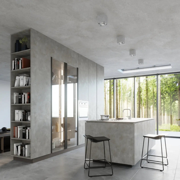 Plafonnier valde en béton durable avec îlot de cuisine texturé facile à nettoyer et portes vitrées intégrant des appareils