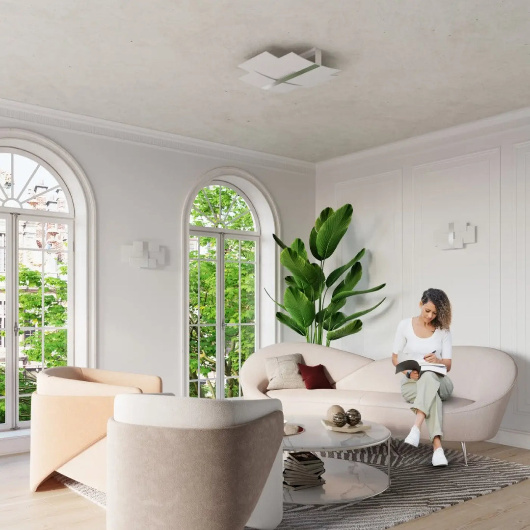 Luminaire plafonnier celia chrome design intemporel avec canapé blanc moderne aux lignes courbes et finition douce