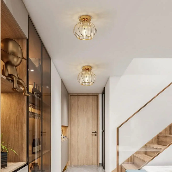Luminaire plafonnier veloria en cage dorée avec globe en cristal transparent et lumière diffuse chaleureuse