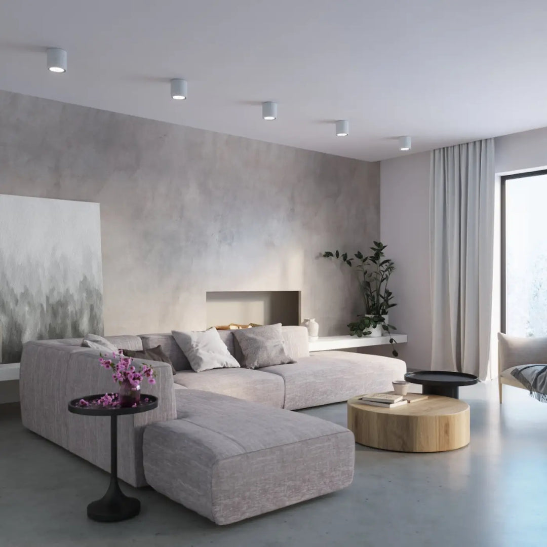 Luminaire plafonnier cullo en béton durable avec forme simple, présenté avec canapé sectionnel gris clair et ottoman