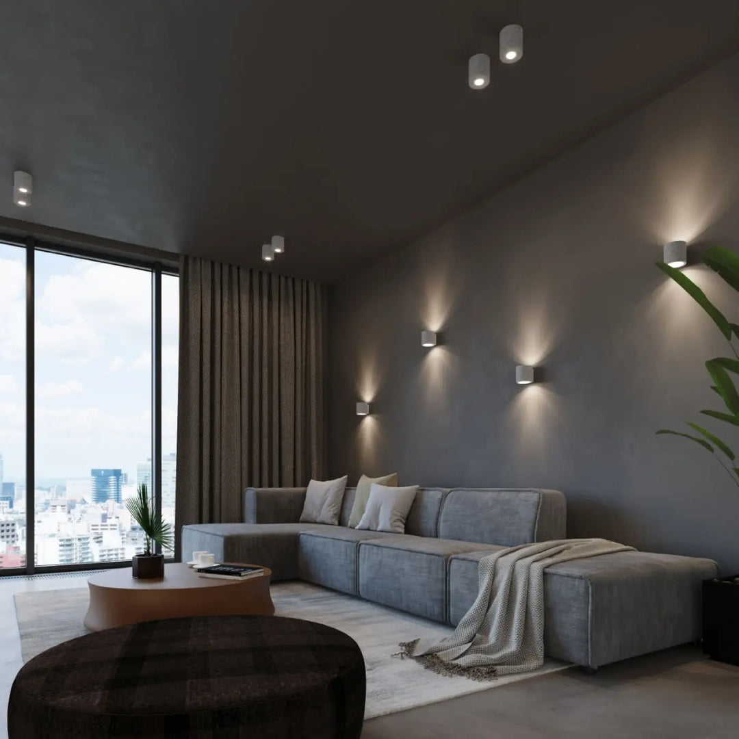 Sectionnel gris avec coussins moelleux et plaid texturé sur laccoudoir sous plafonnier orbis béton luminaire plafonnier orbis béton