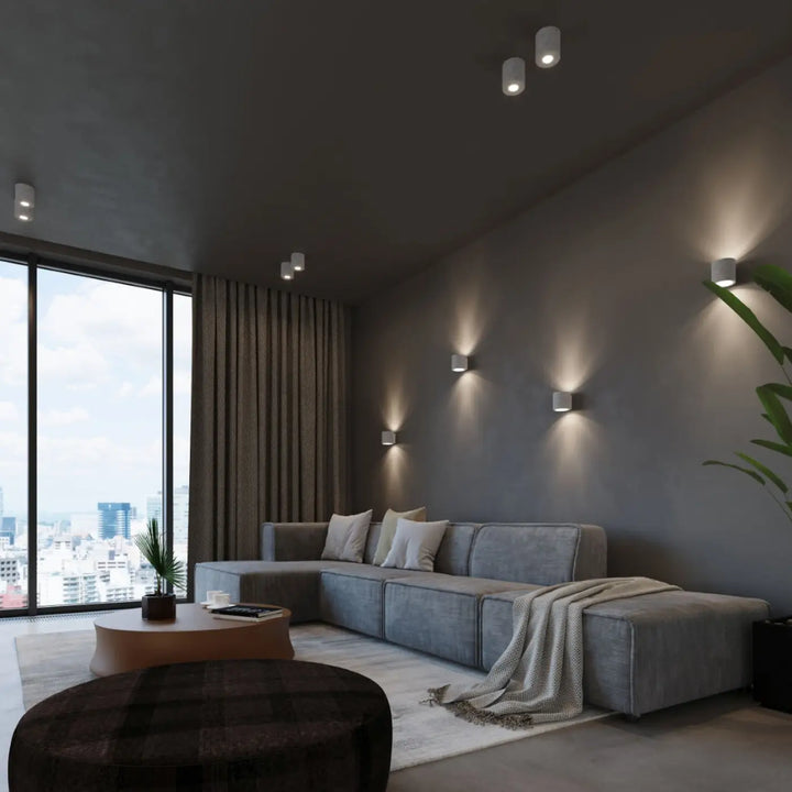 Sectionnel gris avec coussins moelleux et plaid texturé sur laccoudoir sous plafonnier orbis béton luminaire plafonnier orbis béton
