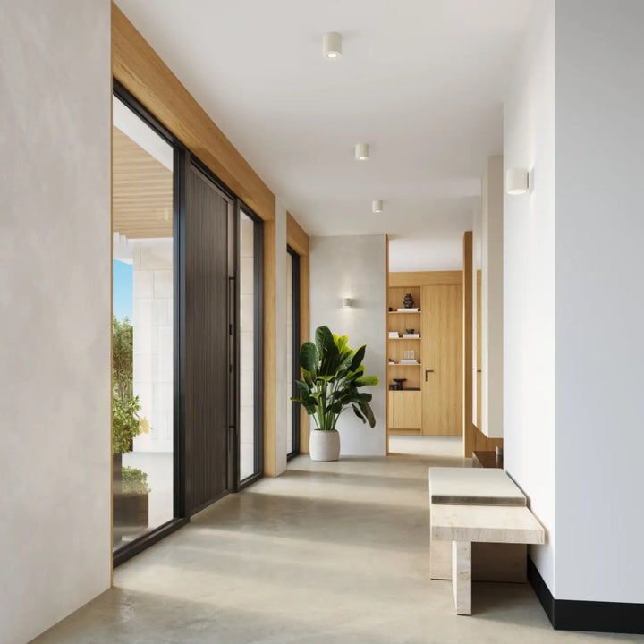 Un plafonnier orbis beige à forme moderne avec un accent décoratif unique près d’une plante verte en pot blanc