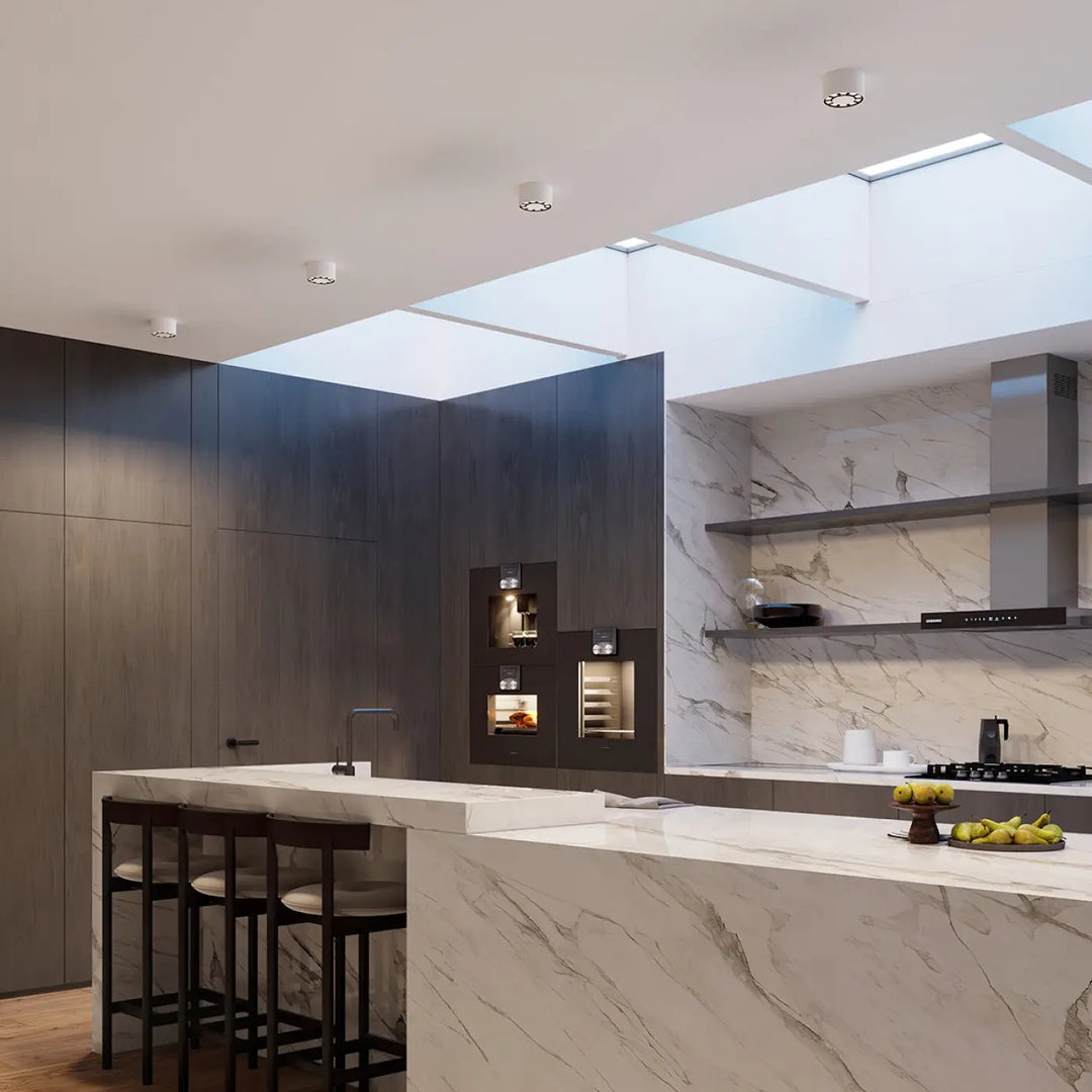 Luminaire plafonnier dio led blanc au-dessus d’un îlot de cuisine en marbre blanc et bois sombre caractéristique loft