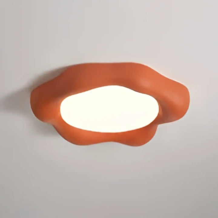 Luminaire plafonnier design nuage avec éclairage blanc doux au centre dans une forme asymétrique orange
