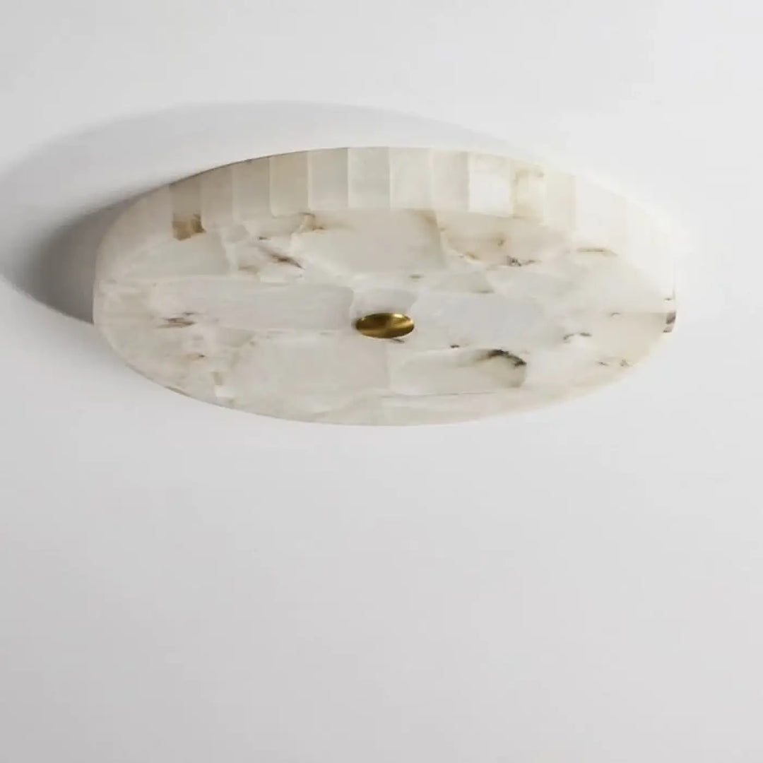 Plafonnier design circulaire en pierre nacrée blanc avec texture facettée et accent central en laiton pour décoration intérieure