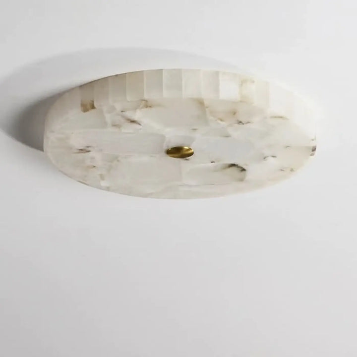 Plafonnier design circulaire en pierre nacrée blanc avec texture facettée et accent central en laiton pour décoration intérieure