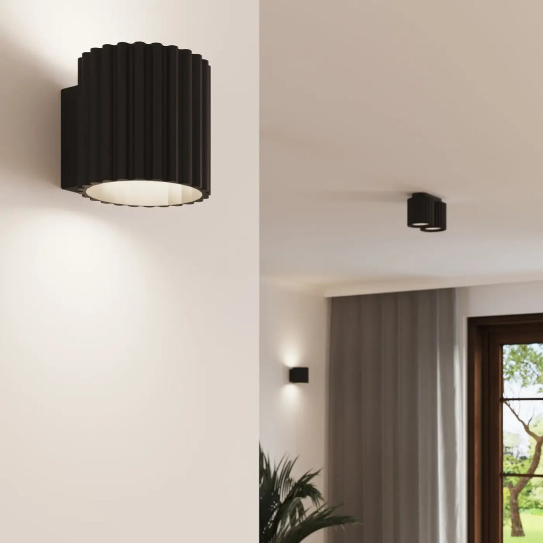 Luminaire plafonnier aura 2 noir avec forme unique inspirée et extérieur cannelé diffusant une lumière chaude circulaire