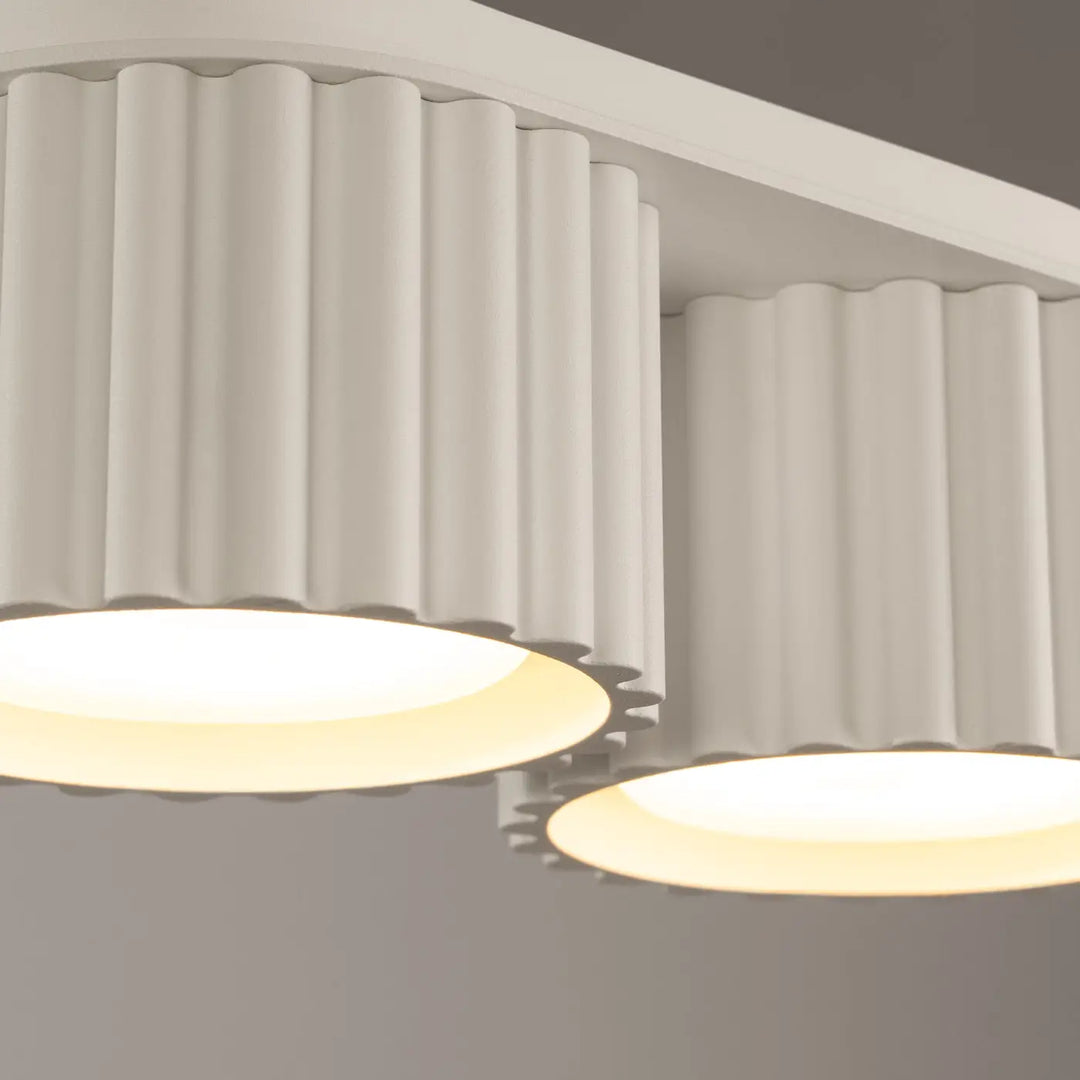 Luminaire plafonnier aura 2 beige avec forme unique inspirée et abat-jours cylindriques cannelés blancs et panneaux lumineux chauds