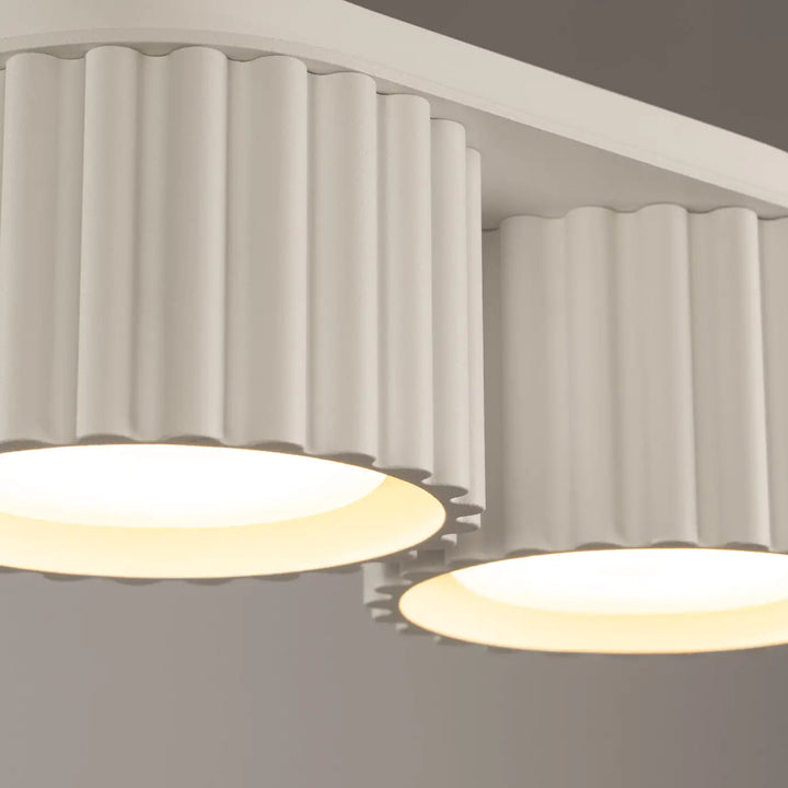 Luminaire plafonnier aura 2 beige avec forme unique inspirée et abat-jours cylindriques cannelés blancs et panneaux lumineux chauds