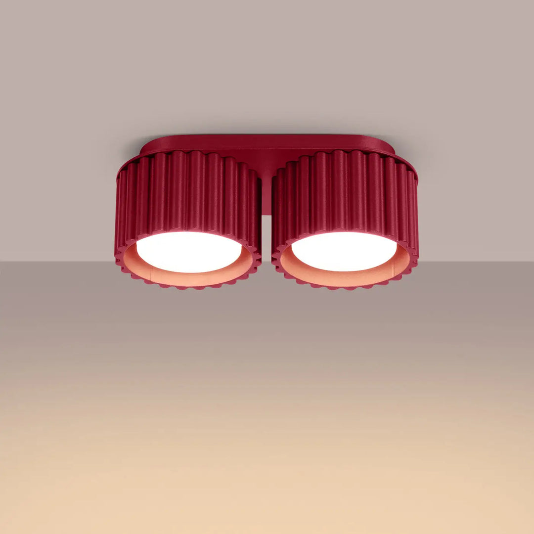 Luminaire plafonnier aura 2 bordeaux avec forme unique inspirée de doubles abat-jours cylindriques en verre cannelé rouge sur base métallique élégante