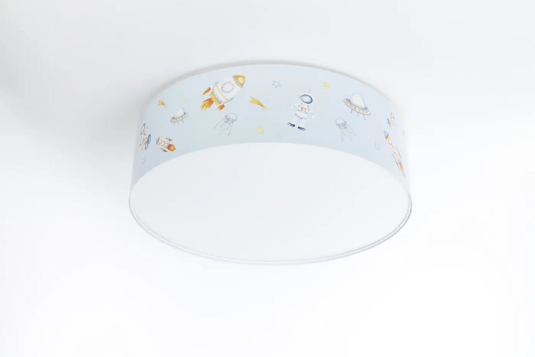 Luminaire plafonnier enfant bleu avec abat-jour translucide pale décoré de fusées et astronautes orange et blanc