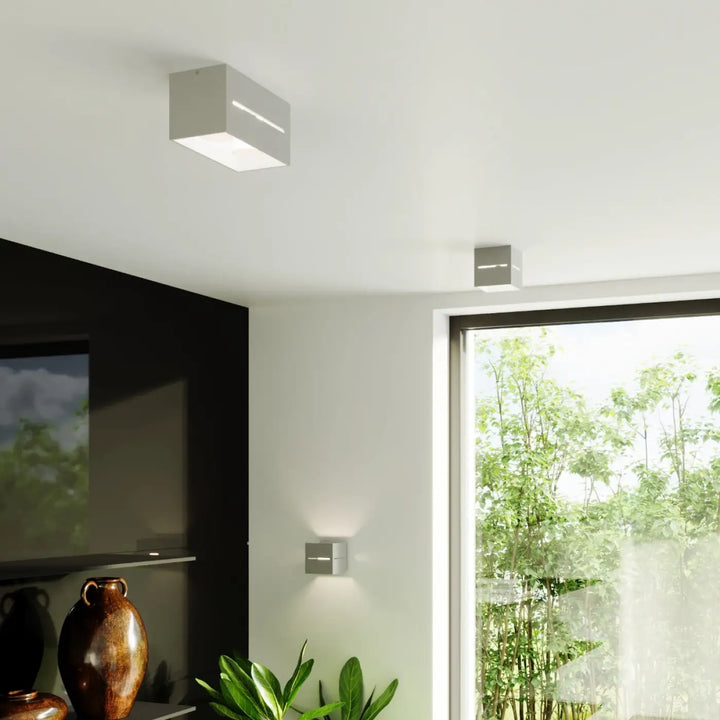 Plafonnier lobo gris au design carré minimaliste avec perforation linéaire et spectacle lumineux à led intégré