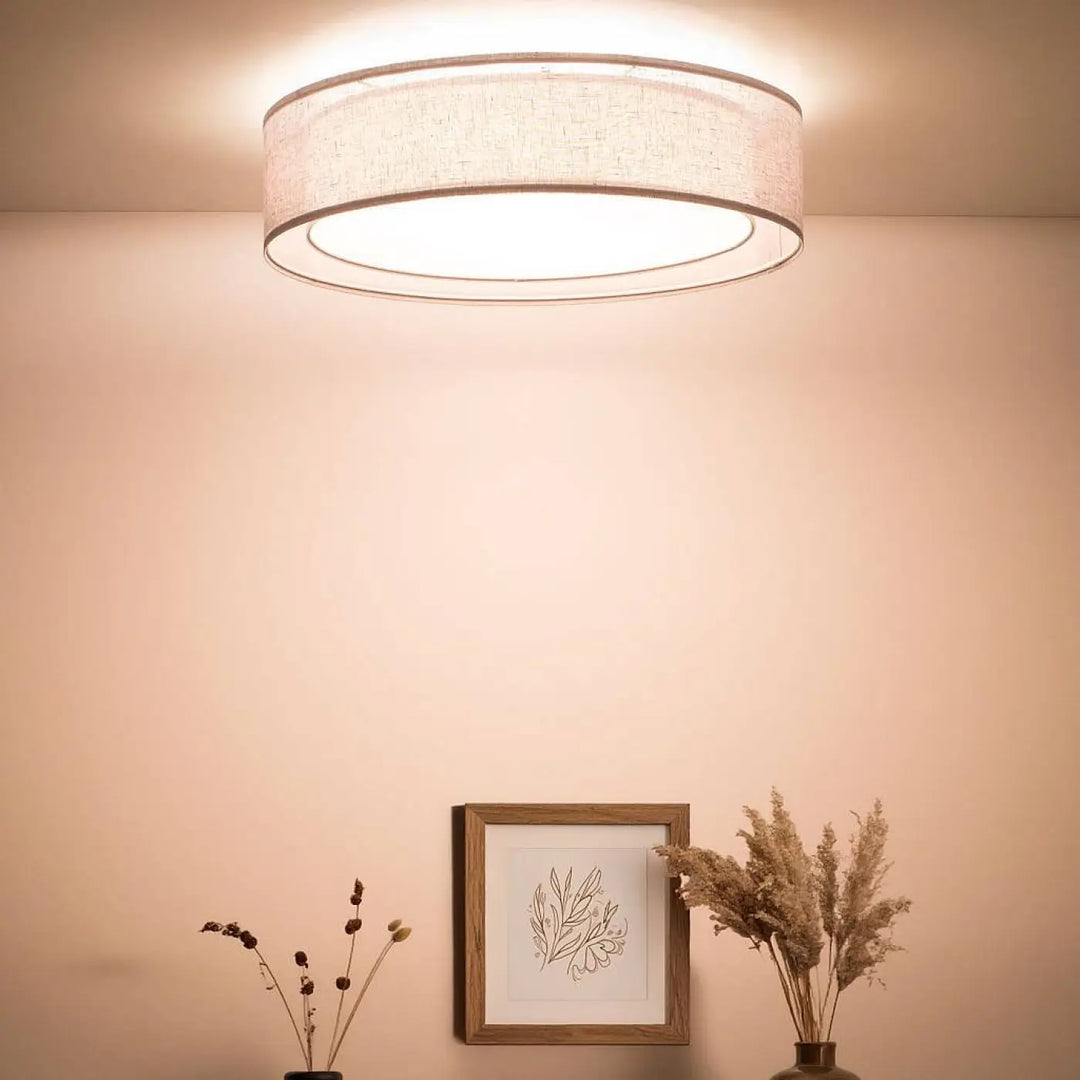 Plafonnier gris platine circulaire avec abat-jour en tissu beige texturé et bord métallique élégant puRO