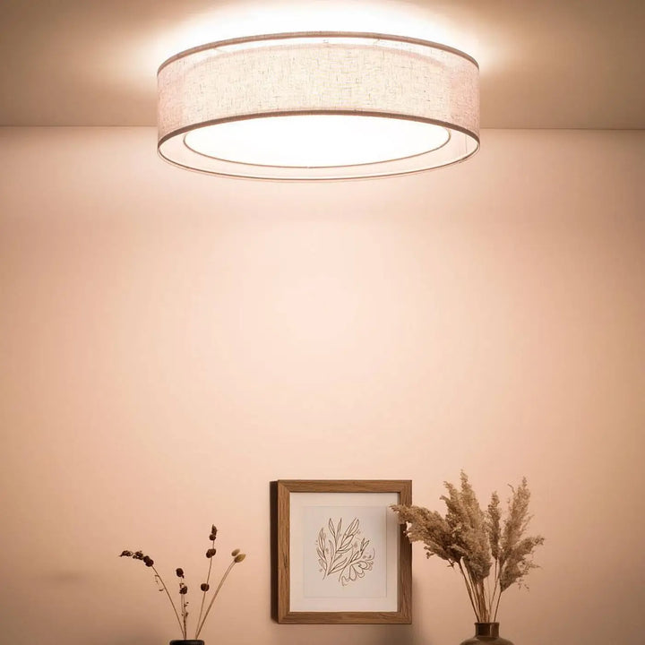 Plafonnier gris platine circulaire avec abat-jour en tissu beige texturé et bord métallique élégant puRO