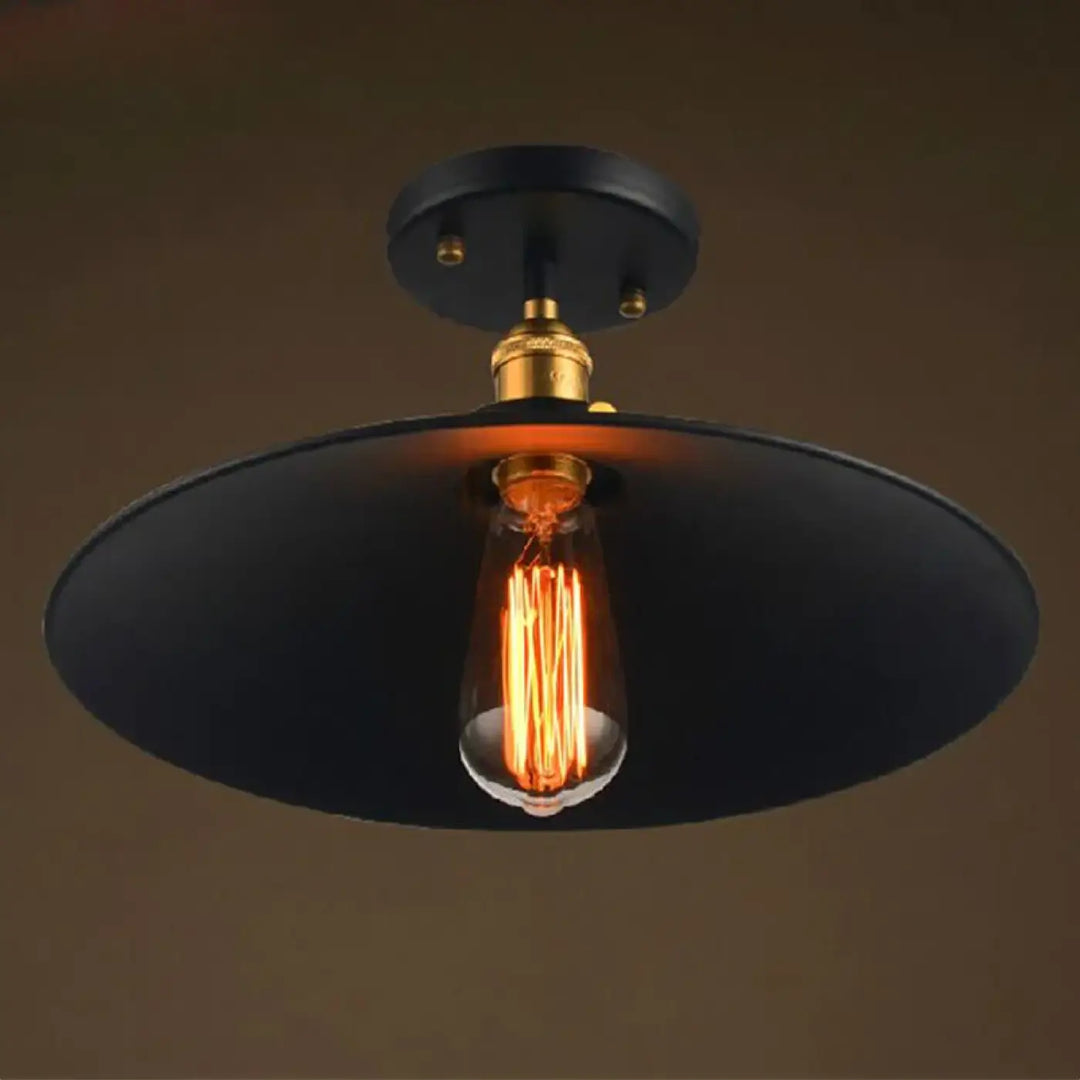 Luminaire plafonnier industriel noir avec douille finition laiton et ampoule edison exposée pour décoration intérieure style industriel