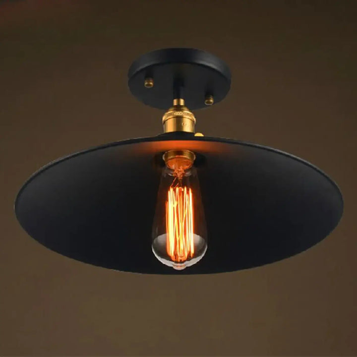 Luminaire plafonnier industriel noir avec douille finition laiton et ampoule edison exposée pour décoration intérieure style industriel