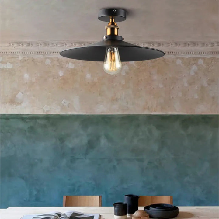 Luminaire plafonnier style industriel noir avec fixation en laiton et ampoule à filament pour décoration intérieure