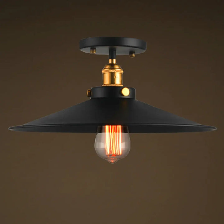 Luminaire plafonnier style industriel noir avec base en laiton et ampoule à filament apparent pour décoration intérieure