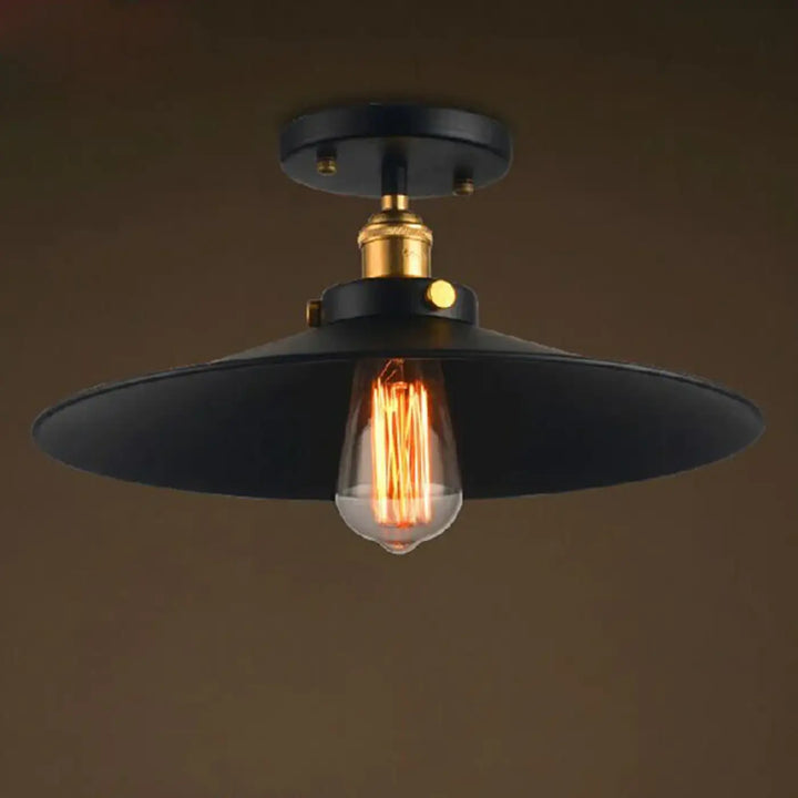 Luminaire plafonnier style industriel noir avec fixation centrale laiton et ampoule filament pour décoration intérieure