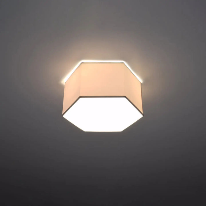 Luminaire plafonnier sunde 15 blanc avec forme géométrique hexagonale et abat-jour en tissu beige diffusant une lumière chaude