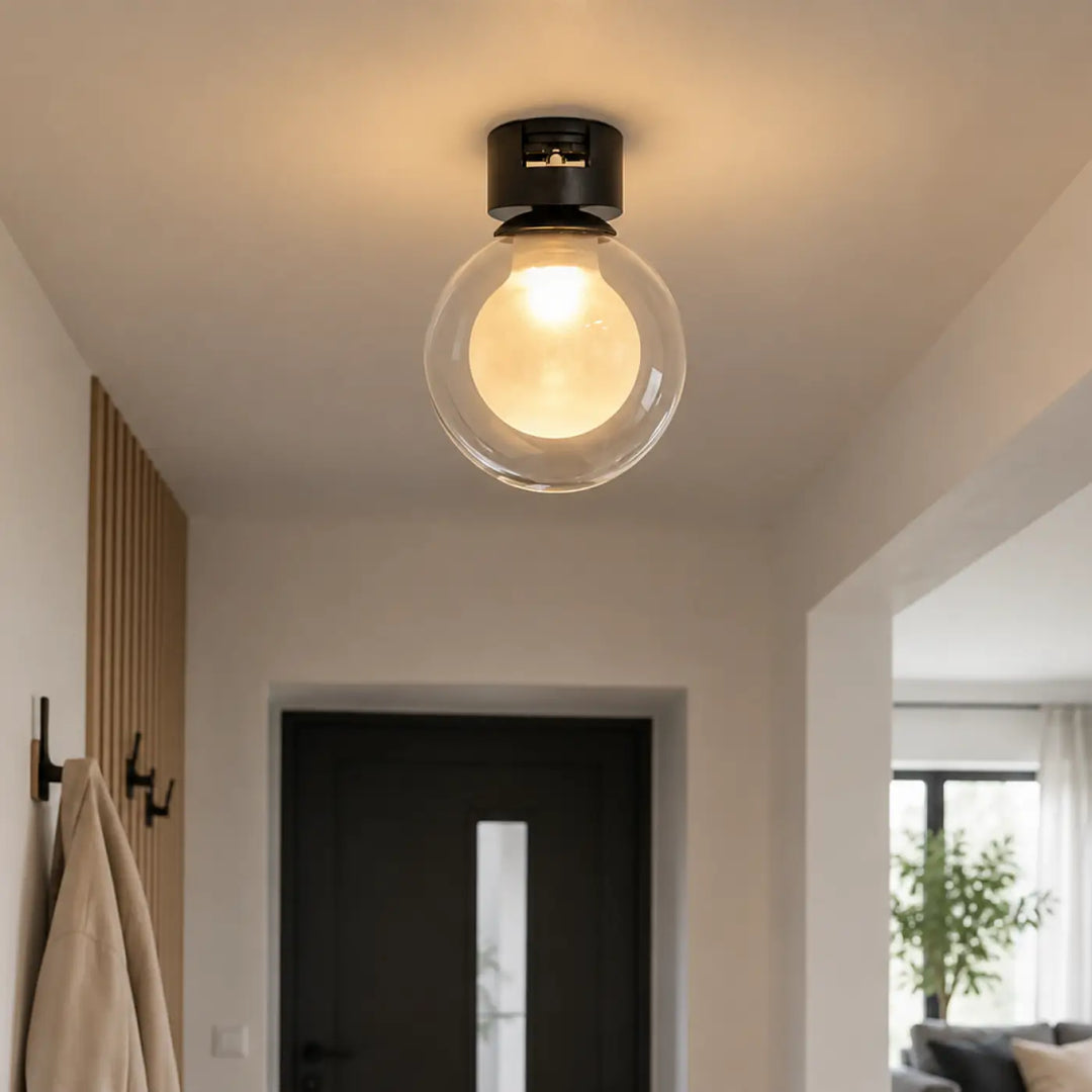 Luminaire plafonnier minimaliste noir avec globe en verre clair et ampoule intégrée modèle acia monté au plafond