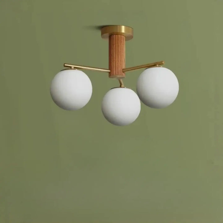 Luminaire plafonnier moderne cortix avec trois globes en verre blanc et colonne centrale en finition noyer nervurée