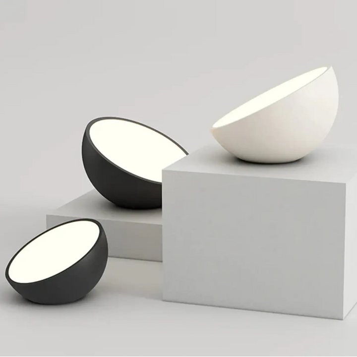Luminaire plafonnier cosma avec coque arrondie en céramique mate noire et blanche diffusant une lumière diffuse douce