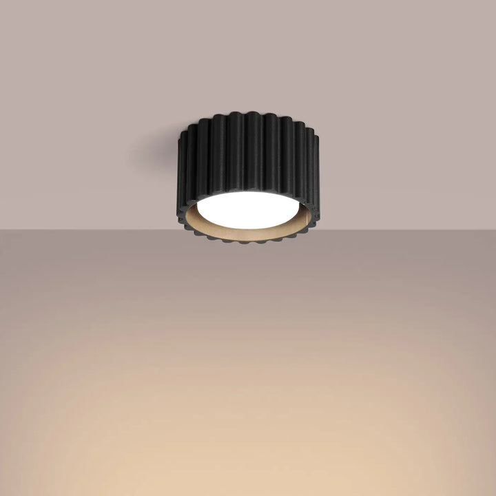 Luminaire plafonnier aura 1 noir avec forme unique inspirée cylindre noir texturé et centre lumineux blanc chaud