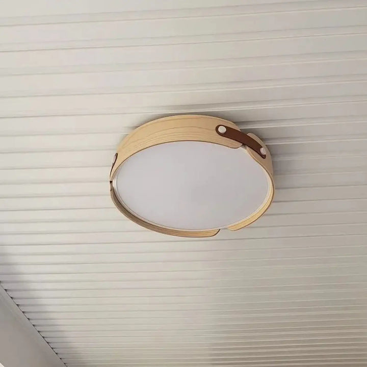 Luminaire plafonnier rond avec cadre en bois naturel et détails inspirés de sangles en cuir marron tanox