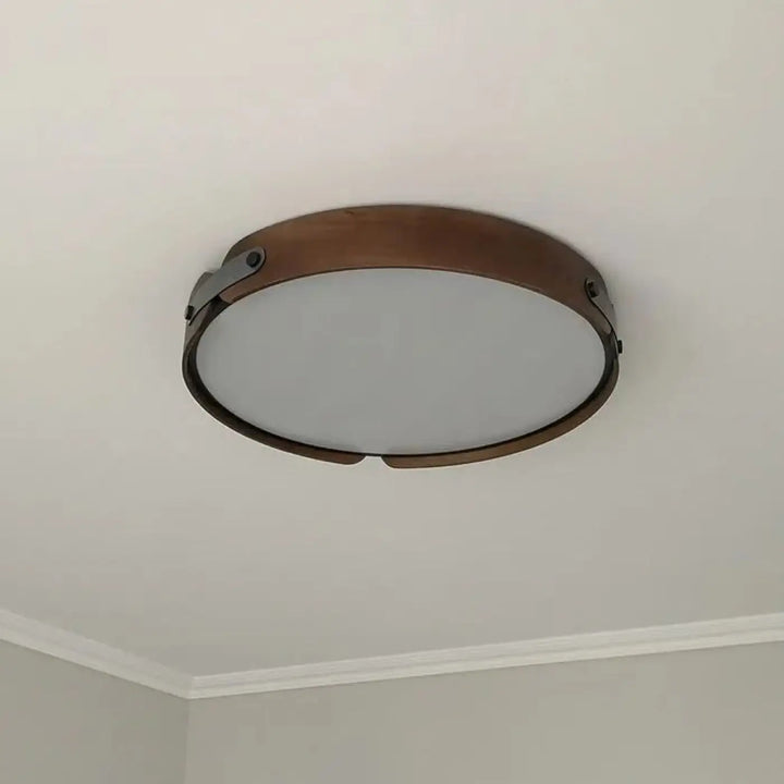 Luminaire plafonnier rond tanox avec cadre en métal bronze et panneau en verre dépoli aux détails inspirés