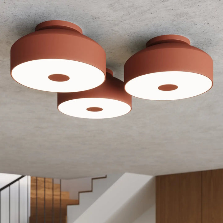 Plafonnier omiq rouge ocre en terre cuite moderne avec trois têtes lumineuses circulaires allie simplicité et design exceptionnel