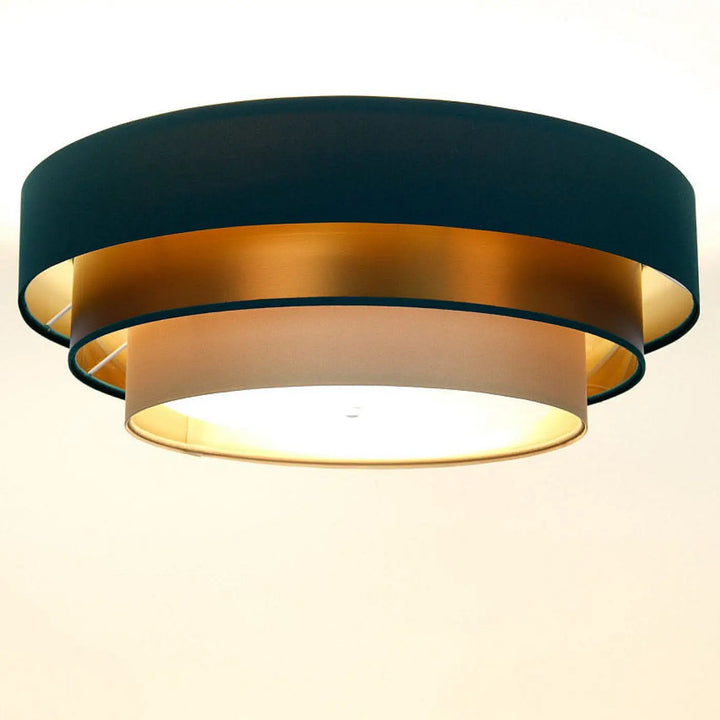 Luminaire plafonnier vert avec trois abat-jour circulaires concentriques en tissu beige, vert profond et cuivre brossé