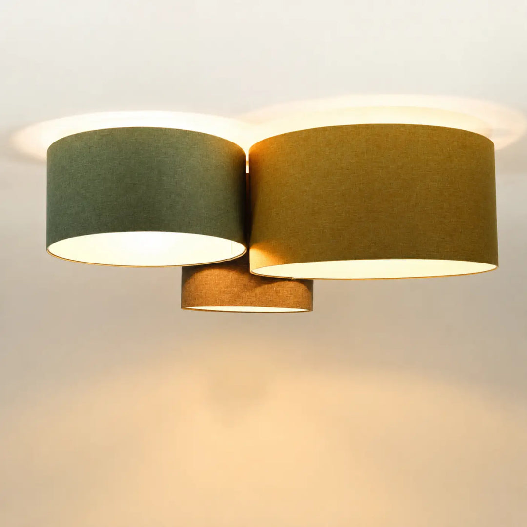 Luminaire plafonnier trio boho elegant avec trois abat-jours cylindriques en tissu lin naturel moutarde et gris vert