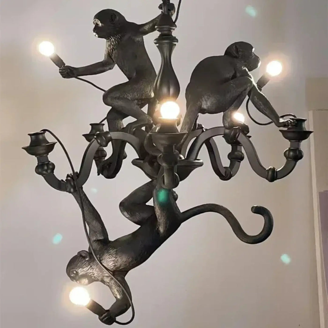Lustre contemporaine noir avec singes sculptés en poses dynamiques tenant des ampoules pour une allure animée
