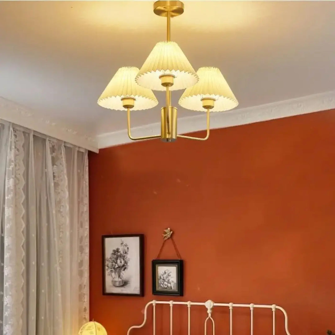 Suspension luminaire sandyra avec trois abat-jour en tissu plissé crème et finition dorée idéale pour salle à manger