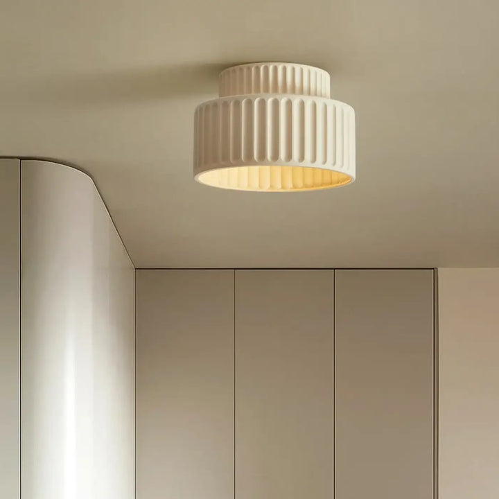 Suspension luminaire crebia crème en matériau côtelé émettant une lumière chaude et douce au plafond
