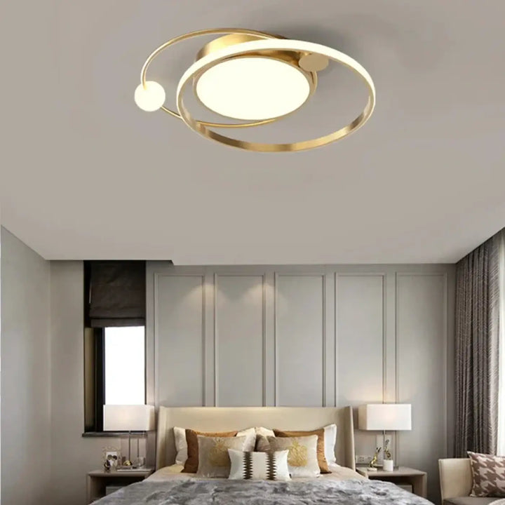 Luminaire plafonnier aloïs en métal doré avec anneaux concentriques et disque central pour lumière blanche ou chaude en salle à manger