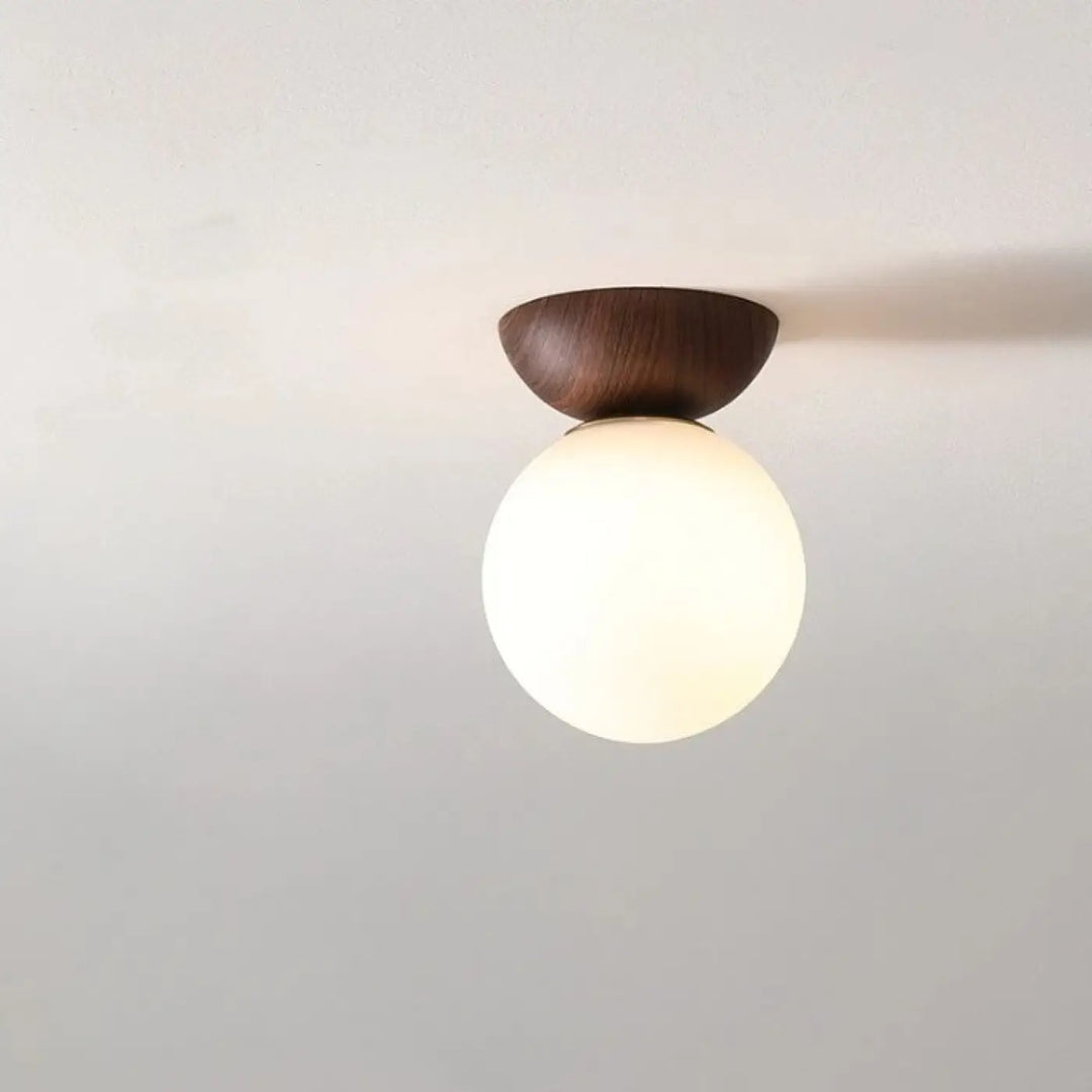 Luminaire plafonnier oako avec base en bois foncé et globe lumineux en verre dépoli pour un plafonnier design épuré