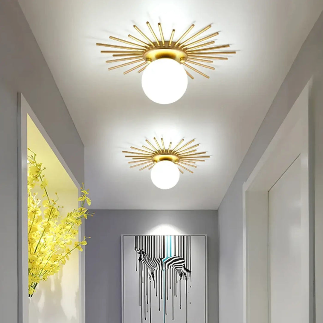 Plafonnier design spika métal doré avec ampoule globe blanche et motif en étoile sunburst