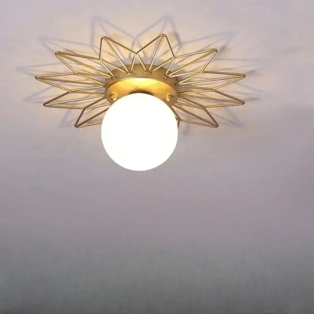 Plafonnier design spika en métal doré avec lumière étoilée et globe en verre dépoli pour un intérieur élégant