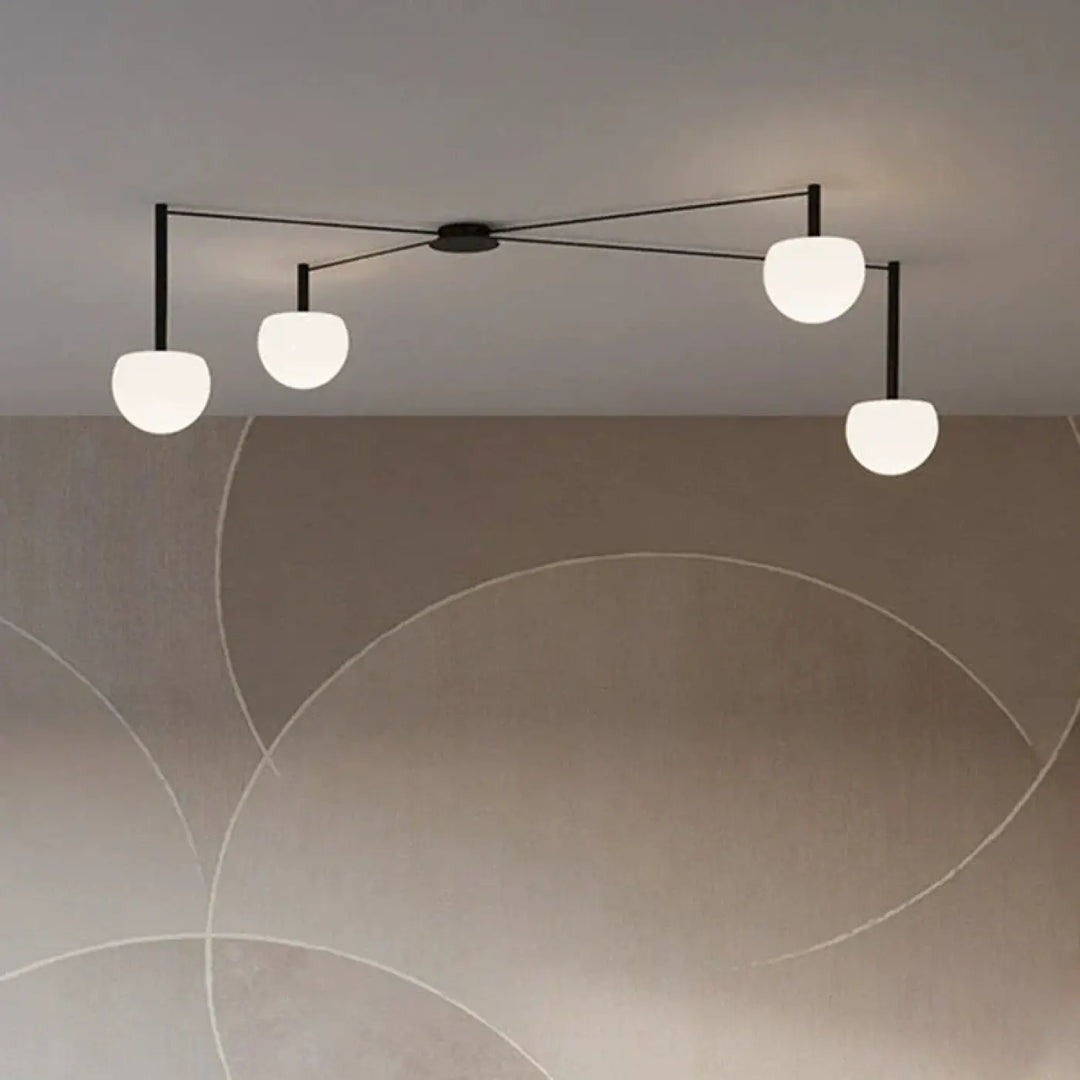 Plafonnier design aiko en métal noir avec quatre globes en verre dépoli pour décoration intérieure univers déco moderne